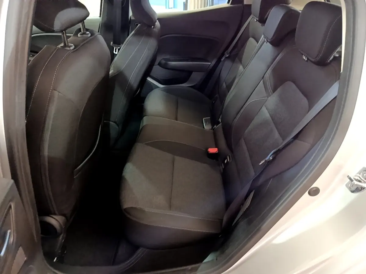 Vue côté droit sur la banquette arrière noire de la Renault Clio Business E-TECH 140, sièges tissu et ceinture de sécurité visible.