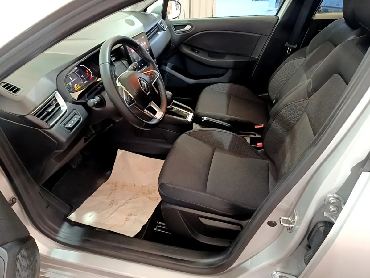 Vue intérieure côté conducteur de la Renault Clio Business E-TECH 140 2022, sièges noirs et volant multifonctions en cuir.