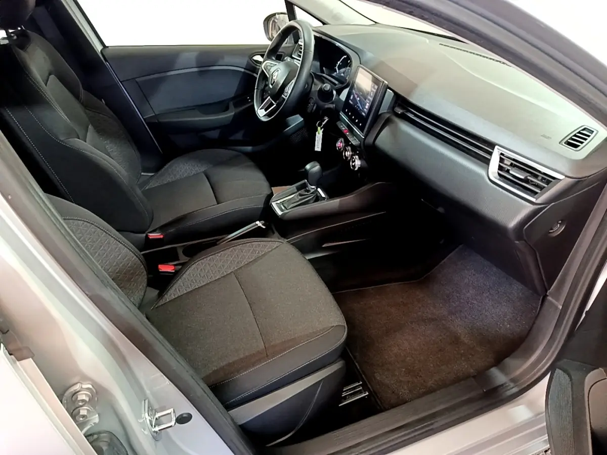 Intérieur avant droit de la Renault Clio Business E-TECH 140 gris foncé, sièges tissu noirs et tableau de bord moderne.