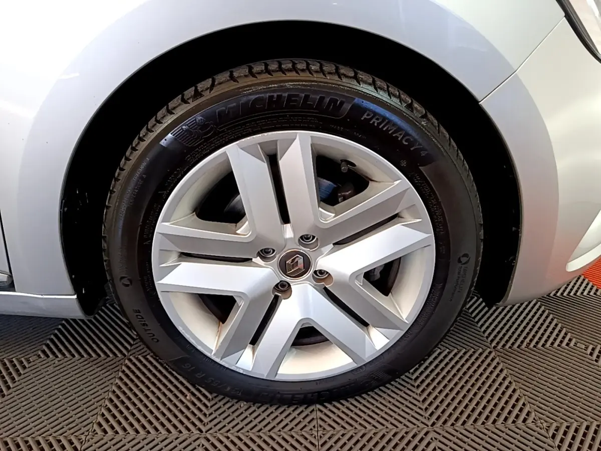 Vue rapprochée sur la roue avant droite d'une Renault Clio Business E-TECH 140 gris foncé, avec passage de roue visible.