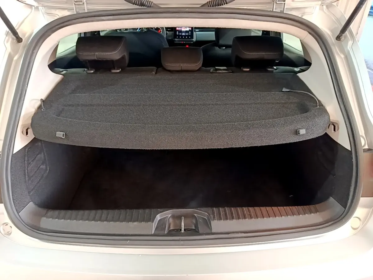 Coffre ouvert d'une Renault Clio gris foncé, vue arrière montrant la tablette cache-bagages et banquette rabattable.