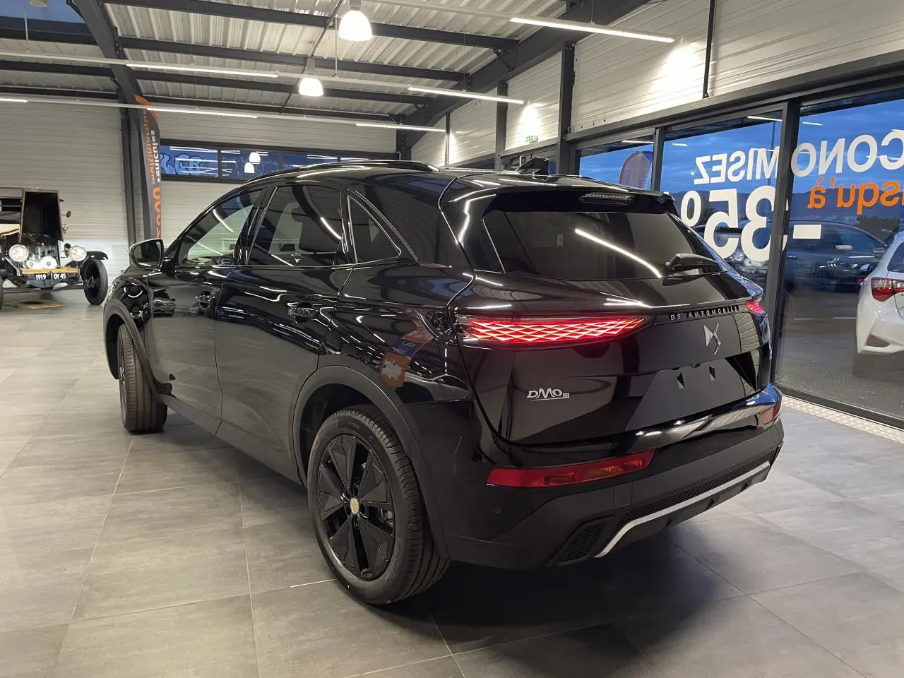 Vue 3/4 arrière droite du DS7 Crossback noir métallisé avec feux arrière LED et jantes alliage noires.