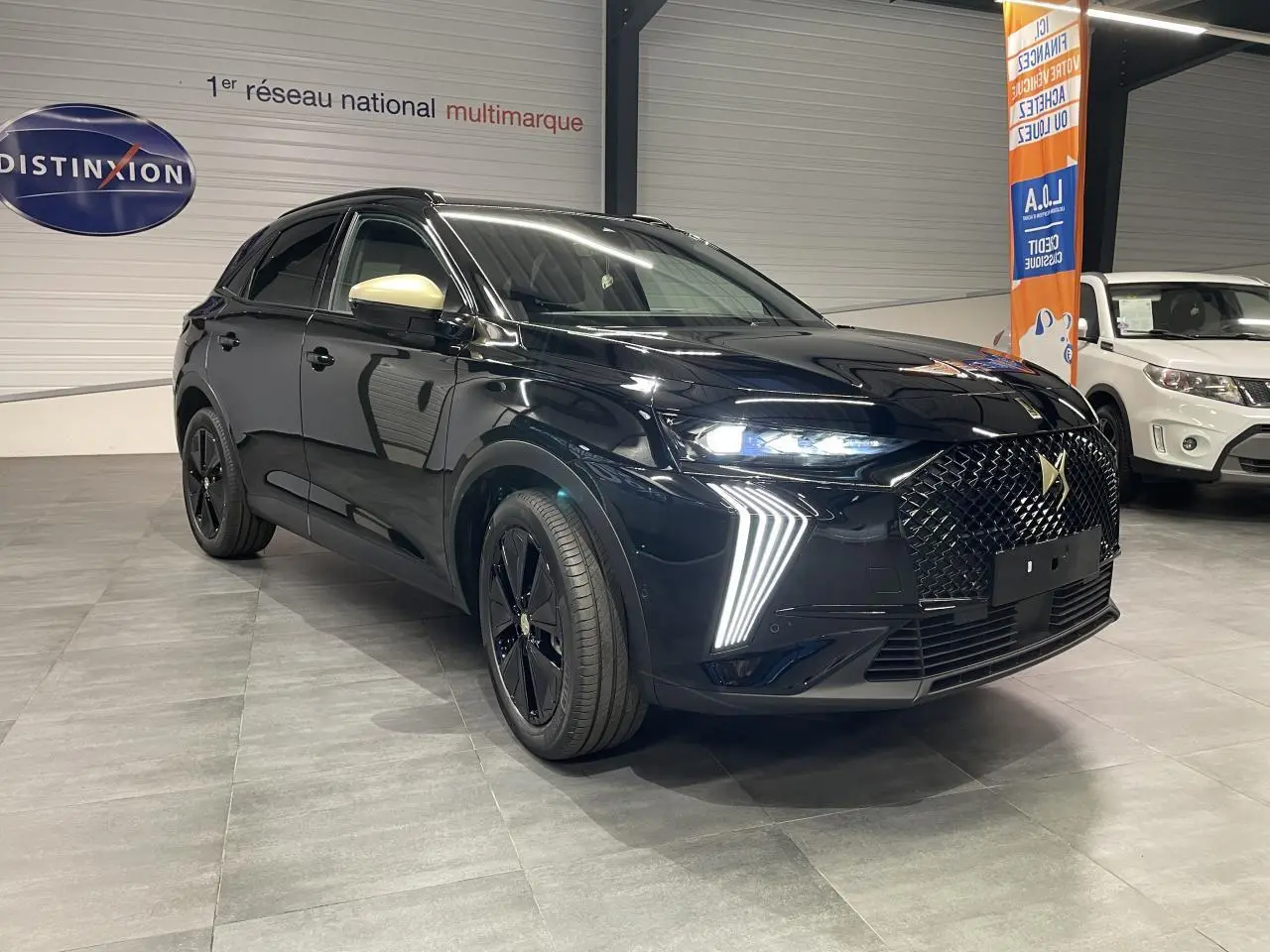 DS7 Crossback noir métallisé en 3/4 avant droit avec calandre DS Wings et rétroviseurs dorés satinés.