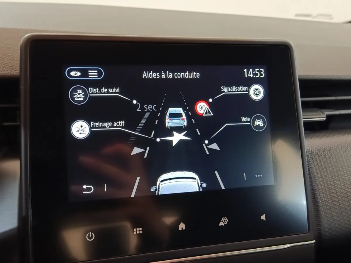 Écran tactile central de la Renault Clio Business blanc montrant l’aide à la conduite avec alertes de distance et voie.