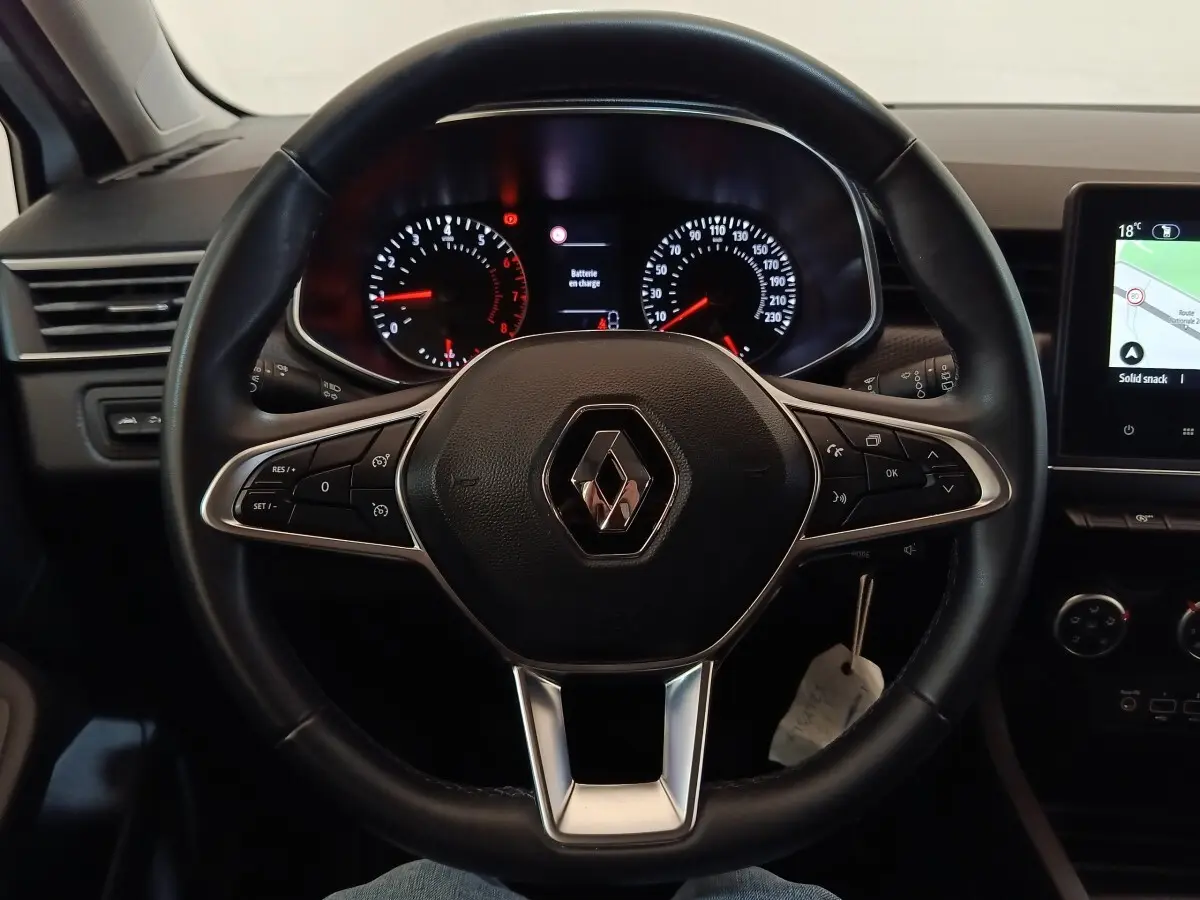 Vue rapprochée du volant cuir noir multifonctions de la Renault Clio 2021 avec tableau de bord et écran tactile.