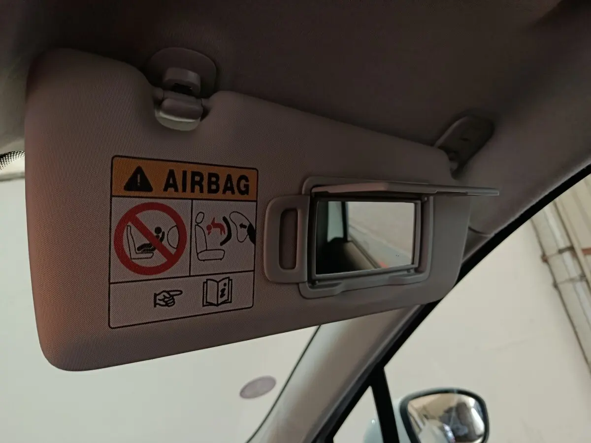 Détail du pare-soleil côté conducteur avec miroir et avertissement airbag dans une Renault Clio blanche 2021.