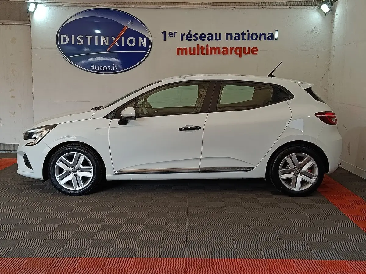 Profil droit d'une Renault Clio Business blanche de 2021, avec jantes alliage et logo Clio sur la porte arrière.