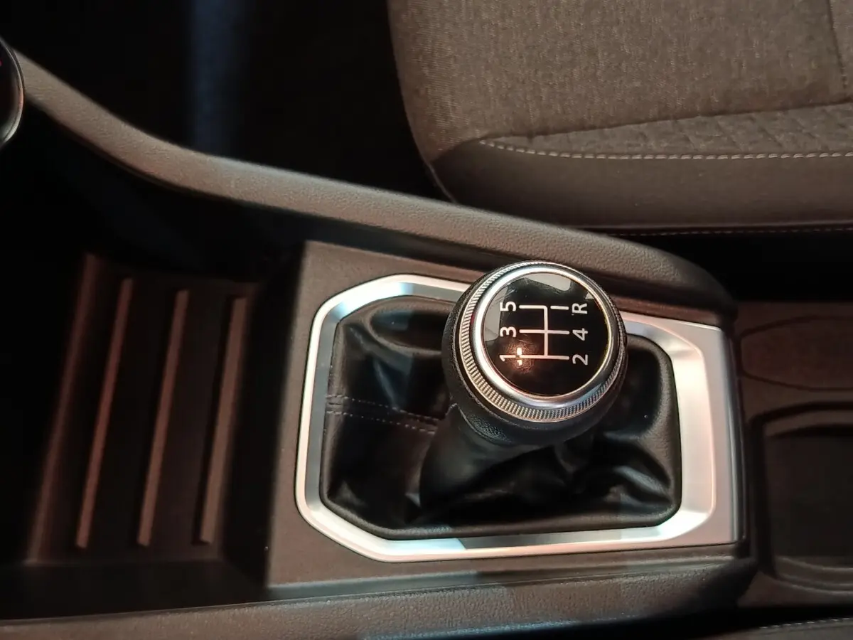 Le levier de vitesse manuel noir avec surpiqûres blanches de la Renault Clio Business SCe 65 vue en gros plan.