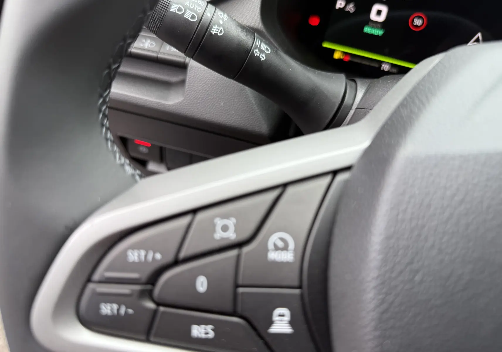 Gros plan sur les commandes au volant du Dacia Bigster 2026, avec tableau de bord numérique en arrière-plan.