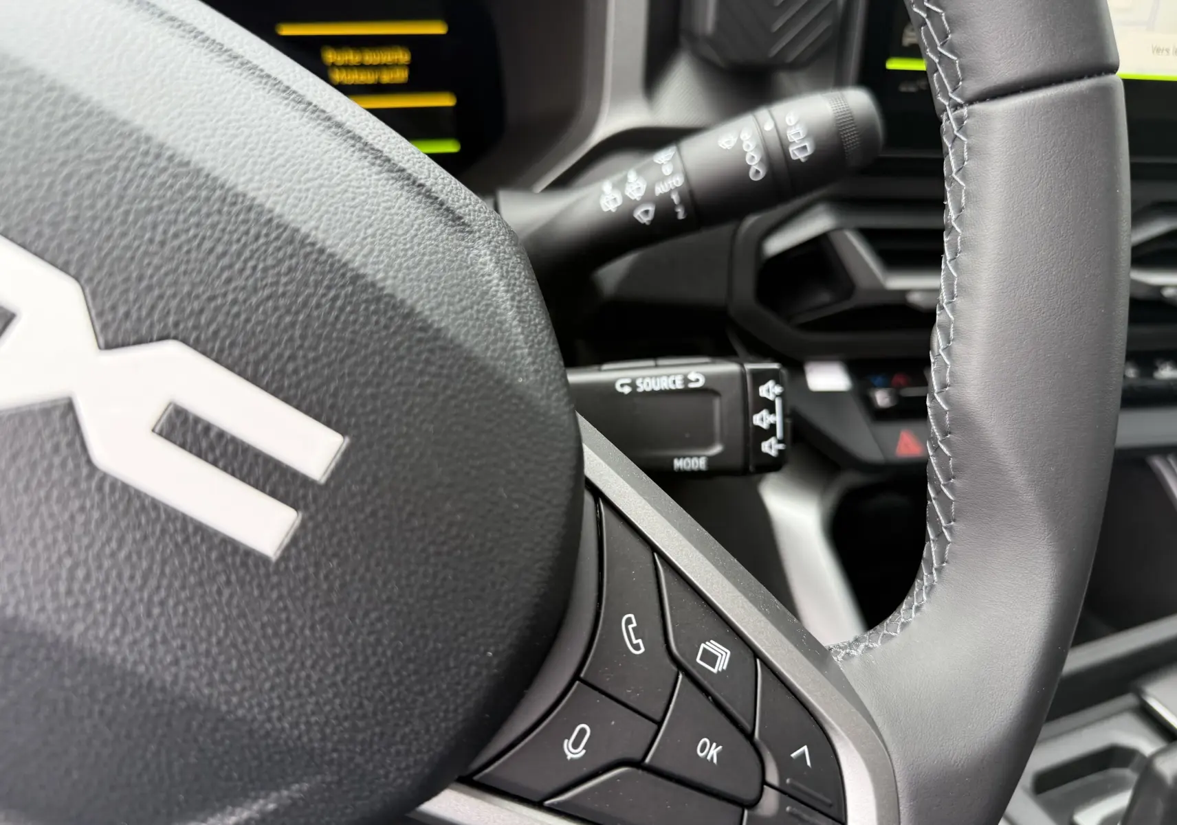 Gros plan sur le volant gris du Dacia Bigster 2026 avec commandes intégrées et partie du tableau de bord visible.