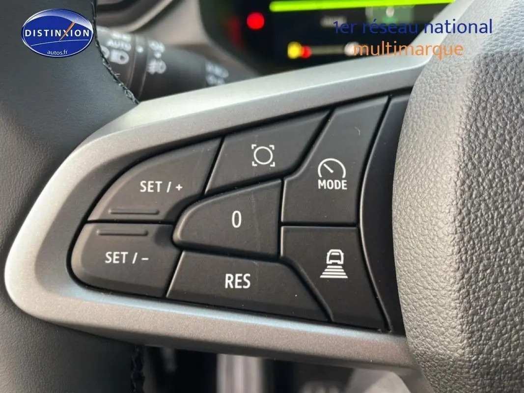 Gros plan sur les commandes au volant à gauche du Dacia Bigster gris schiste métal, montrant les boutons de régulateur de vitesse.