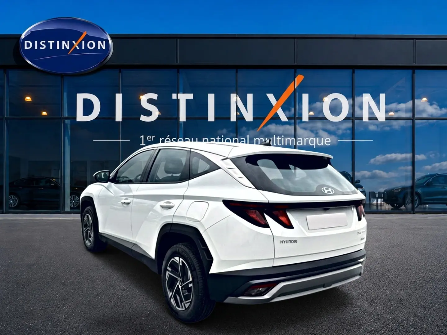 Vue 3/4 arrière droite du Hyundai Tucson blanc hybride 2026 avec jantes alliage et feux arrière LED distinctifs.