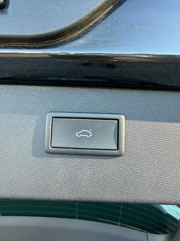 Bouton d'ouverture électrique du coffre sur la garniture intérieure noire du hayon d'un CUPRA Formentor 1.4 e-HYBRID 2024.