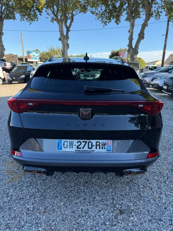 Vue arrière d'une CUPRA Formentor noire 2024 avec feux arrière continus et double sortie d'échappement chromée.