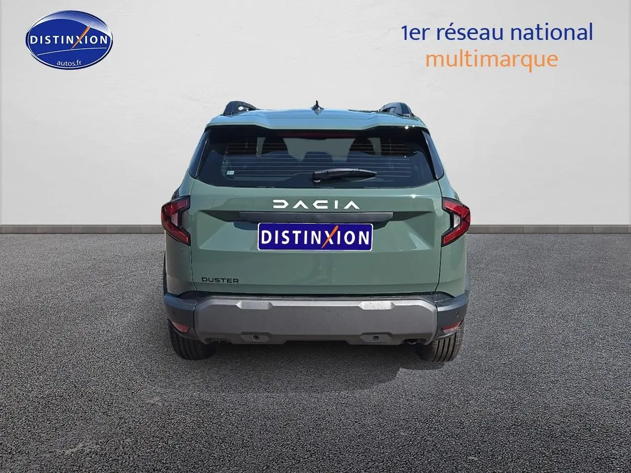 Vue arrière d'un Dacia Duster vert kaki 2025 avec barres de toit et bouclier arrière gris.