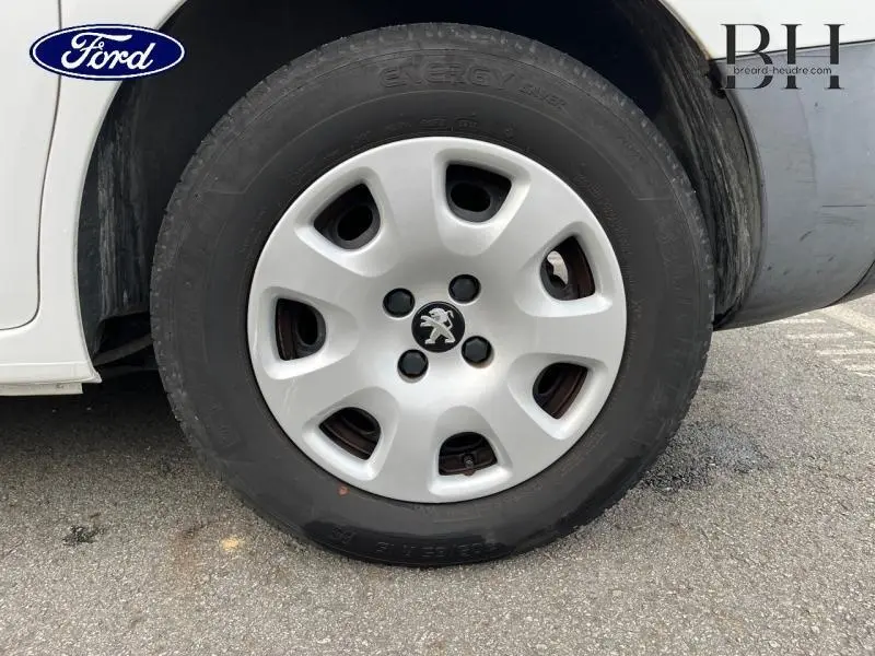 Gros plan sur la roue avant gauche blanche Banquise d'un Peugeot Partner Tepee 2016 avec enjoliveur au lion Peugeot.