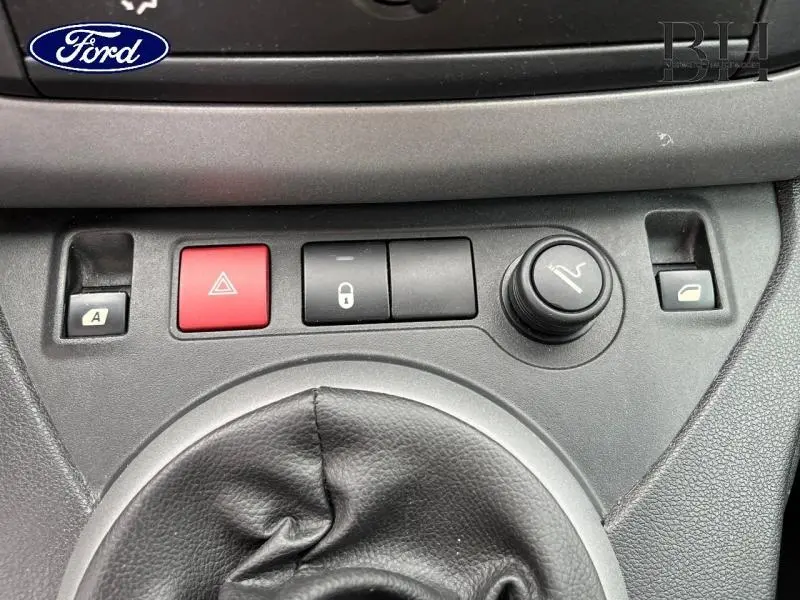 Gros plan sur la console centrale noire avec boutons de verrouillage, warning rouge et commande de fermeture des vitres