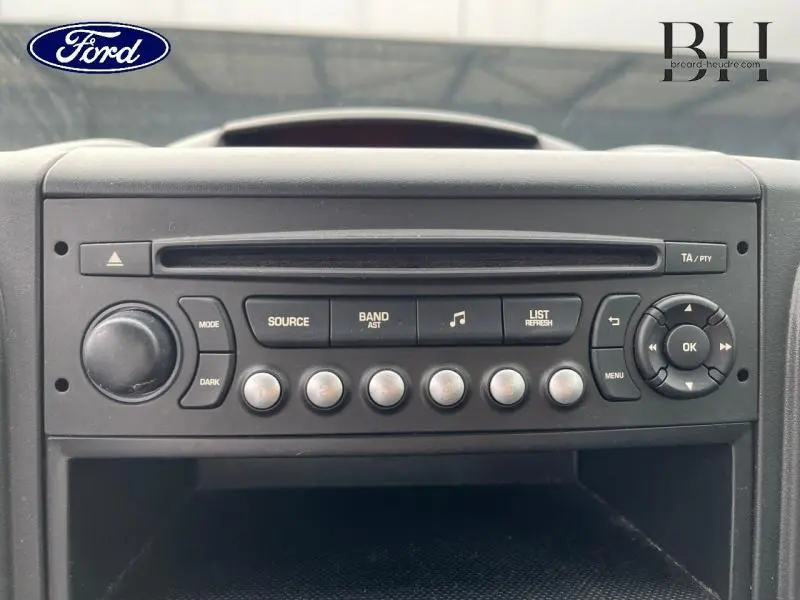 Tableau de bord avec autoradio en gros plan du Peugeot Partner Tepee blanc Banquise, version 2016, vue intérieure frontale.