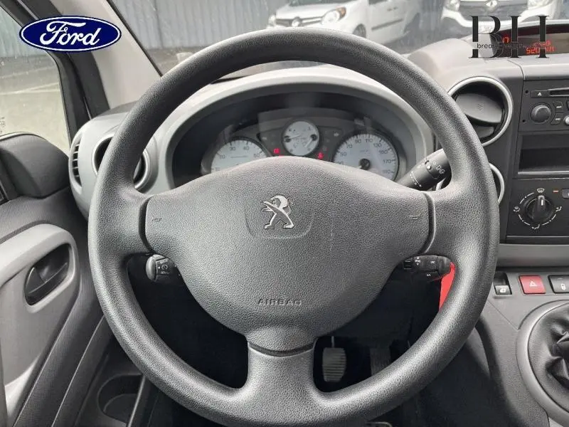 Vue rapprochée du volant noir avec logo Peugeot et tableau de bord clair du Partner Tepee 2016 en intérieur