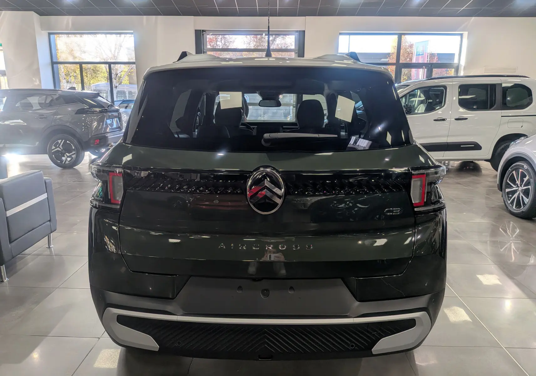 Vue arrière d'un Citroën C3 Aircross Vert Montana avec toit blanc, mettant en valeur son logo et ses feux caractéristiques.