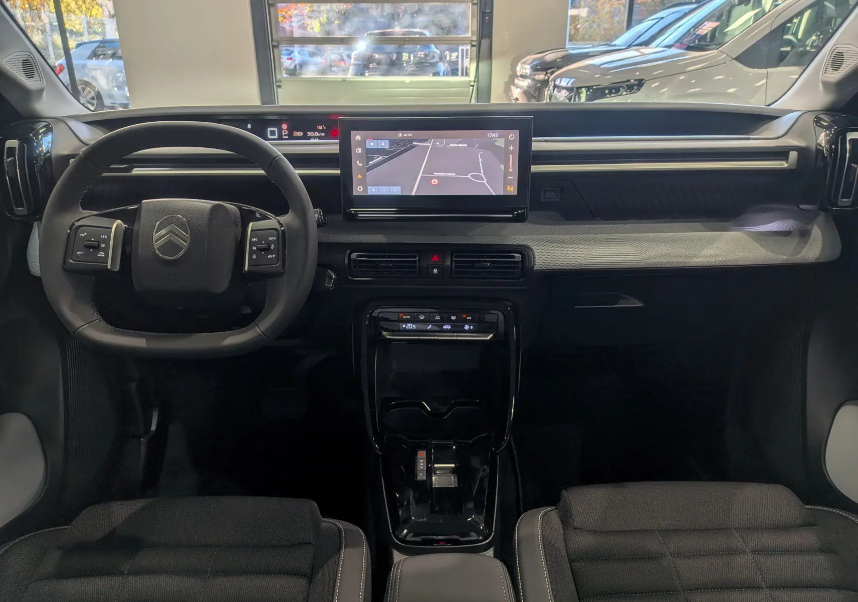 Vue intérieure avant du Citroën C3 Aircross 2025 avec tableau de bord moderne et écran tactile central affichant la navigation.