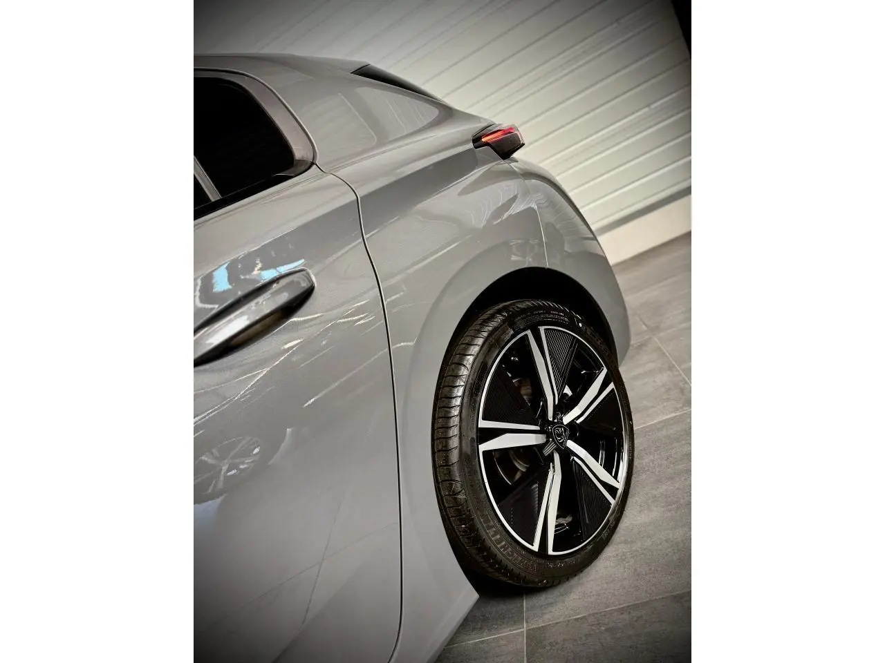 Vue arrière côté gauche de la Peugeot 308 GT gris Selenium, mettant en valeur la jante alliage 18'' Kamakura diamantée.