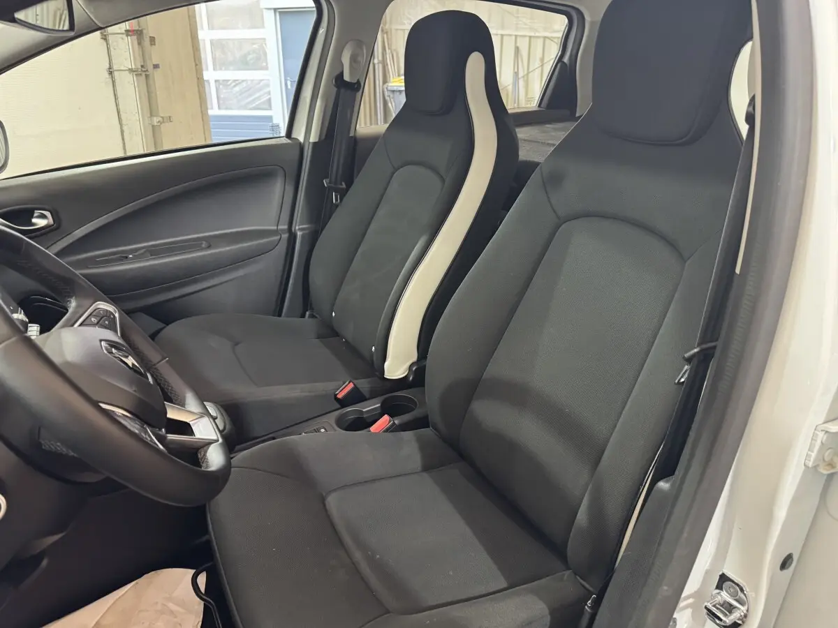 Intérieur de la Renault ZOE Business 2020, vue côté conducteur, sièges noirs avec bandes blanches, portières blanches visibles.
