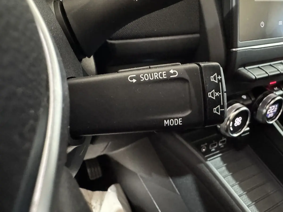 Gros plan sur la commande au volant noir de la Renault ZOE Business Rev R110 2020, avec tableau de bord et écran tactile visibles.