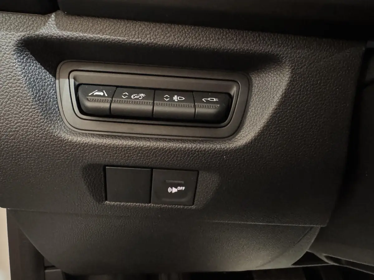 Détail des boutons de commande noirs sur tableau de bord intérieur de la Renault ZOE blanche 2020.