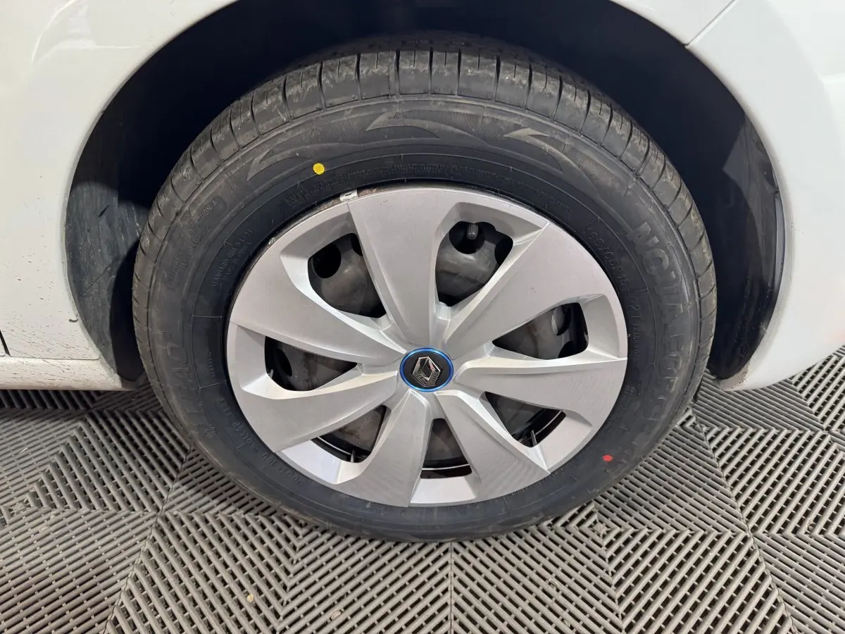 Gros plan sur la roue avant droite blanche d’une Renault ZOE 2020 avec enjoliveur gris et logo Renault central.