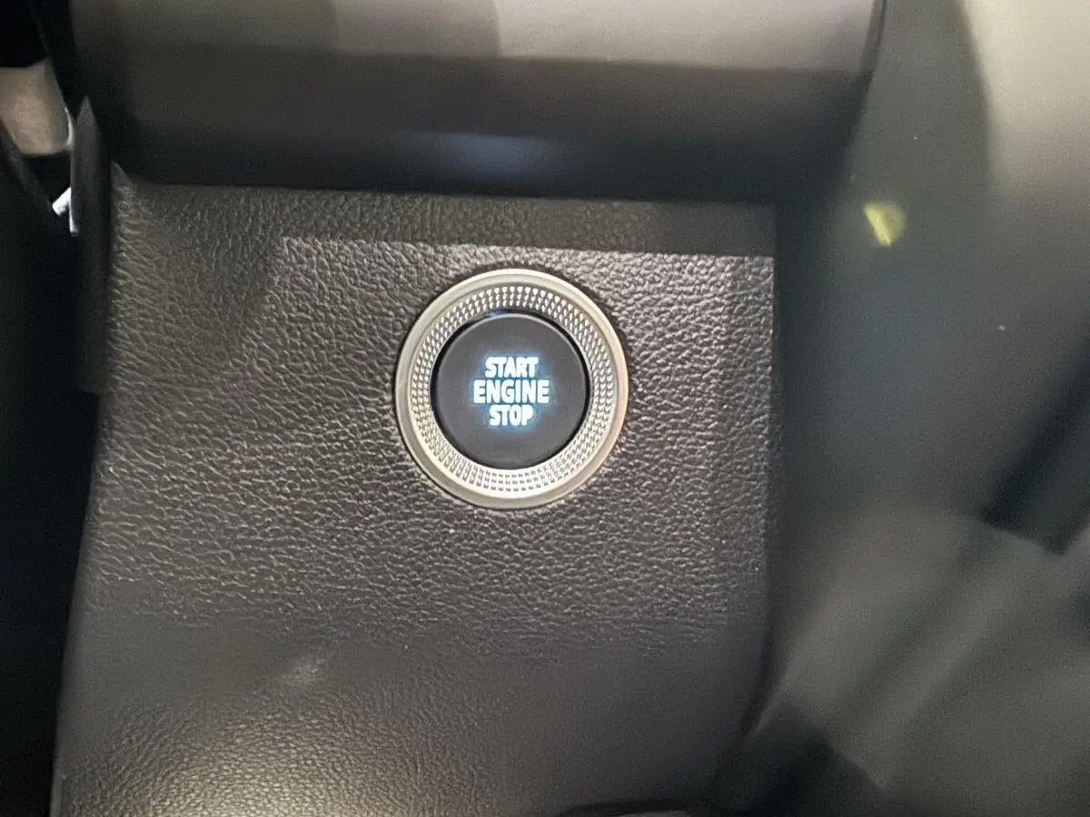 Gros plan sur le bouton démarrage "Start Engine Stop" intégré dans le tableau de bord noir du Renault ZOE blanc 2020.