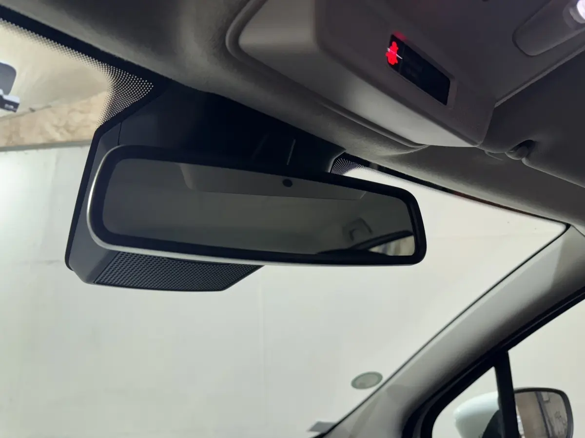 Gros plan sur le rétroviseur intérieur noir de la Renault ZOE Business Rev R110 blanche, vue côté conducteur.