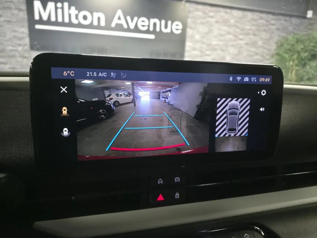 Écran multimédia affichant la caméra de recul et l’aide au stationnement 360° du Fiat 600 rouge, vue intérieure avant.