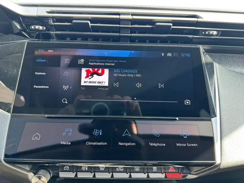 Vue rapprochée de l’écran tactile central multimédia de la Peugeot 308 2025 en gris Artense, affichant la radio NRJ.