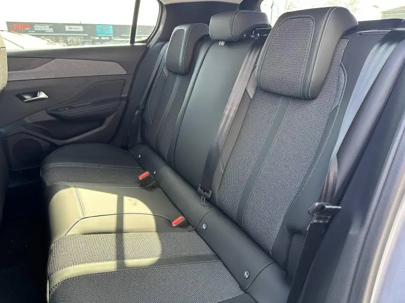 Vue latérale droite de la banquette arrière noire et grise de la Peugeot 308 2025 avec ceintures et appuie-têtes intégrés.