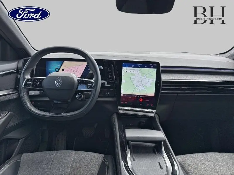 Vue intérieure du tableau de bord du Renault Espace 2024 avec écran tactile vertical et volant multifonction noir.