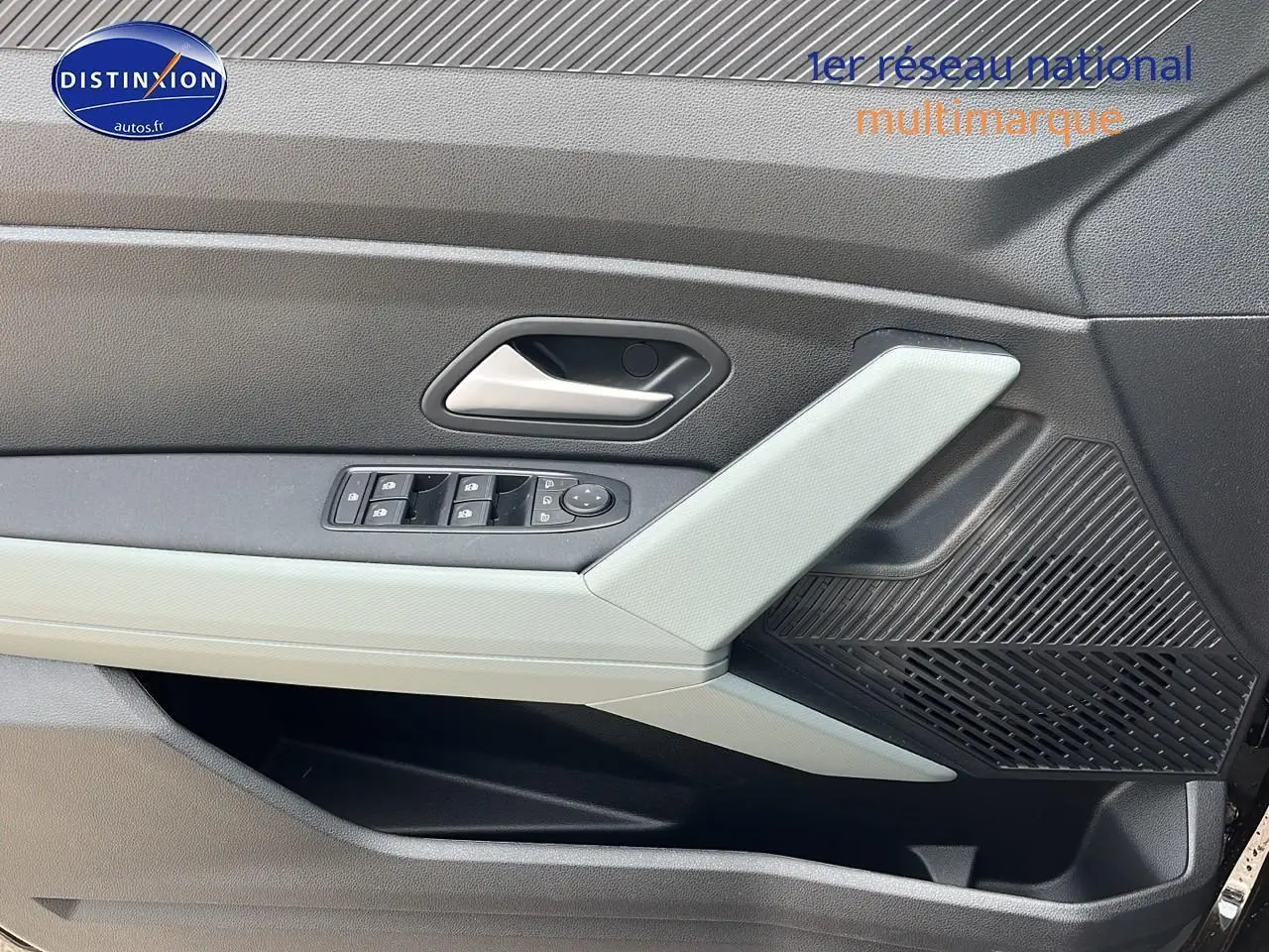 Gros plan sur la porte avant gauche noire du Dacia Duster 2025, avec commandes de vitres et haut-parleur intégré.