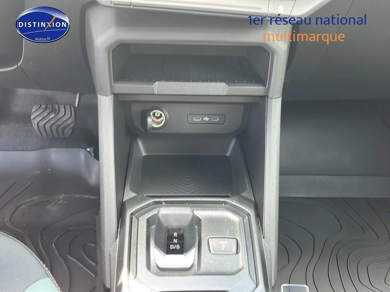 Vue rapprochée de la console centrale du Dacia Duster 2025 noir, montrant levier de vitesses et prises USB.