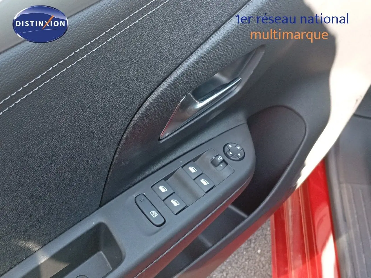 Gros plan sur la commande des vitres et rétroviseurs côté conducteur de l'Opel Corsa rouge à toit noir.