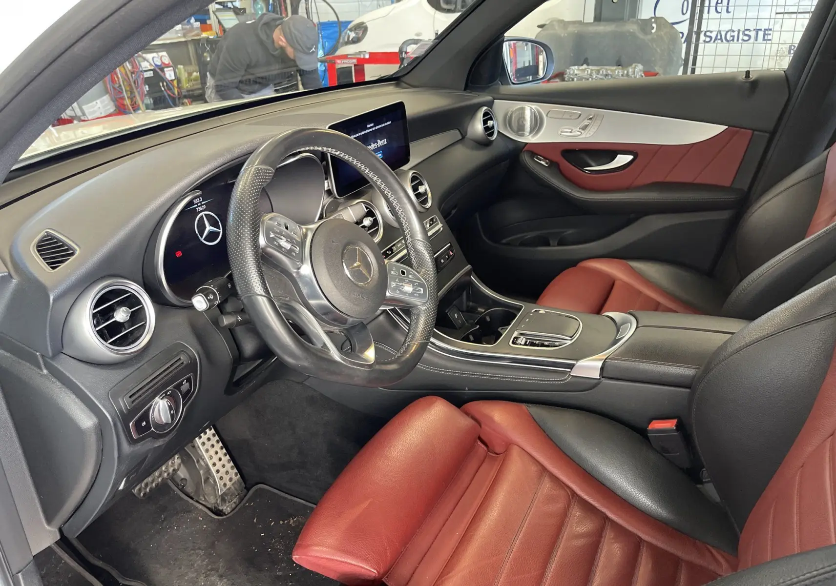 Intérieur du Mercedes GLC Coupé 300 D AMG Line 2019 vu côté conducteur, sièges cuir rouge et tableau de bord noir.