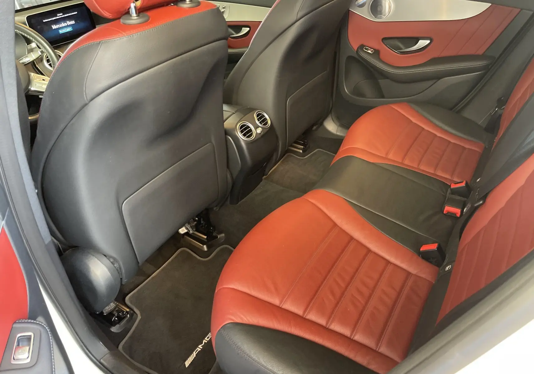 Vue intérieure arrière droite du Mercedes GLC Coupé 300 D AMG Line 2019 avec sièges cuir bicolores rouge et noir.