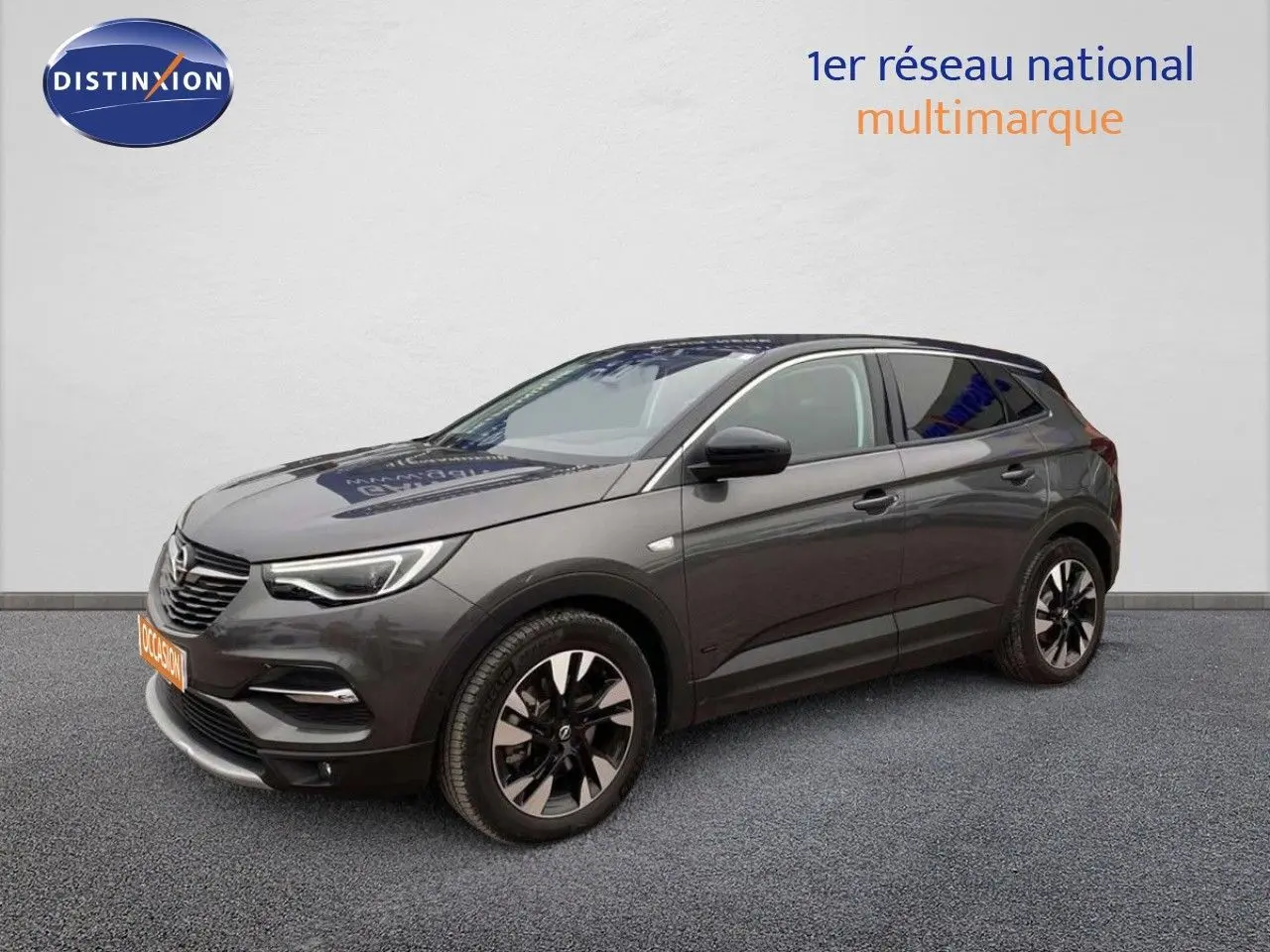 Opel Grandland X gris Pierre de Lune, vue 3/4 avant droit, avec jantes noires et toit panoramique.