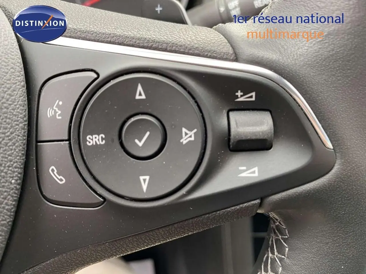 Gros plan sur les commandes du volant noir de l'Opel Grandland X 1.6 Hybrid Turbo 2021, avec boutons multifonctions.