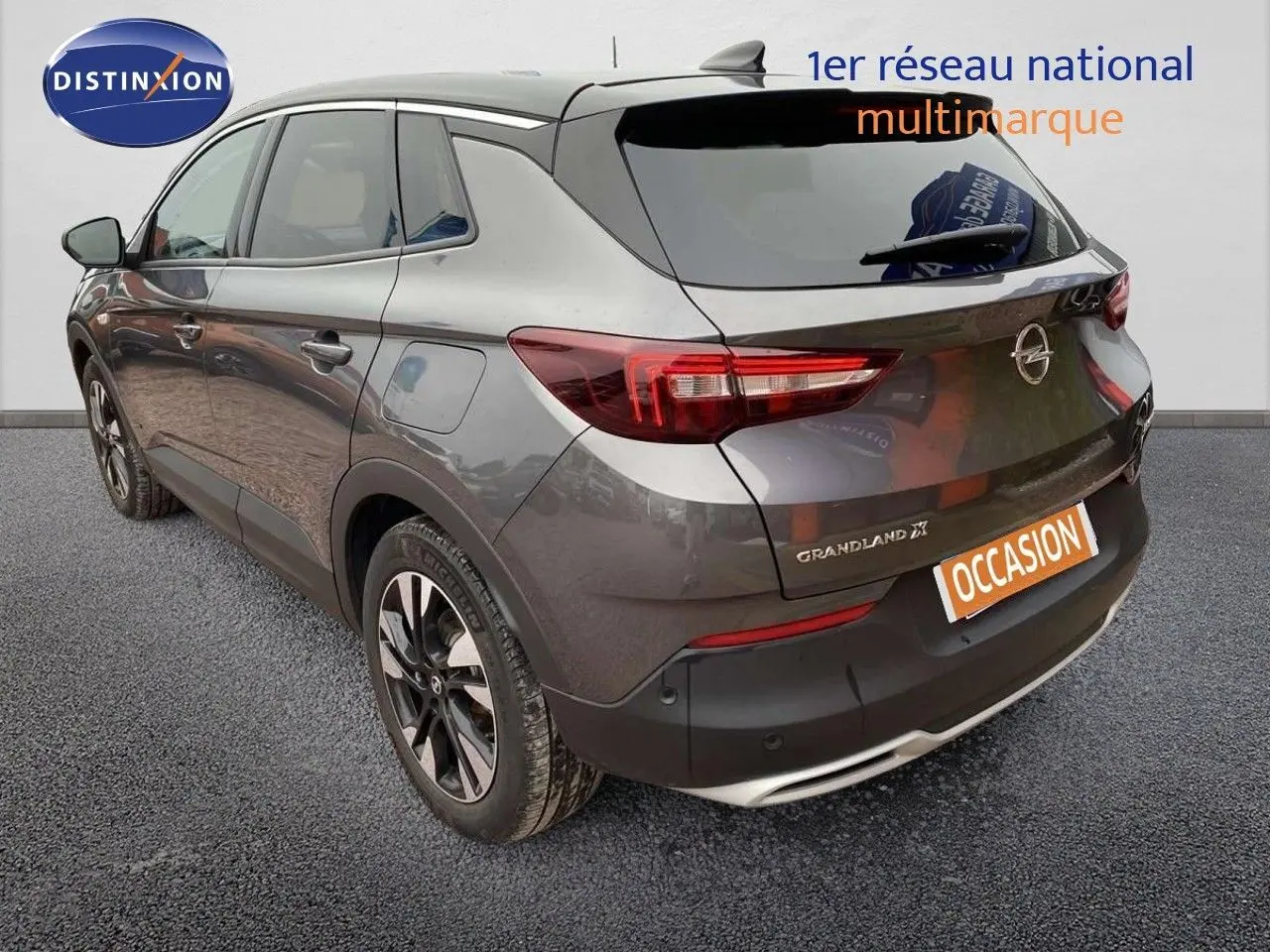 Vue 3/4 arrière droite d’un Opel Grandland X gris Pierre de Lune métallisé avec jantes bi-ton et feux arrière LED.