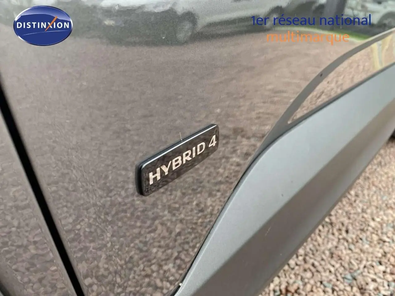 Gros plan sur l’inscription Hybrid 4 sur le côté gauche d’un Opel Grandland X Pierre de Lune métallisé.