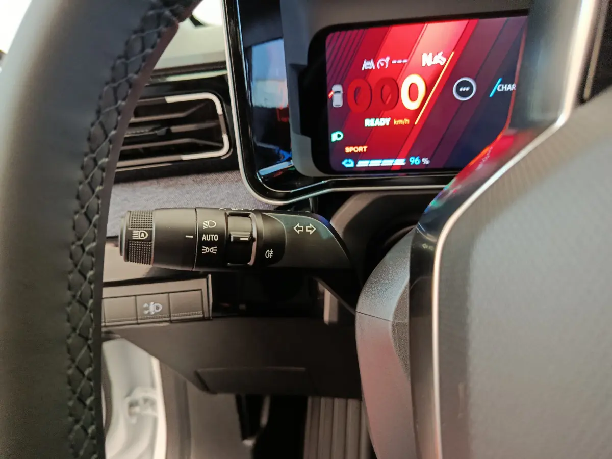 Vue rapprochée du combiné d’instruments digital rouge et noir et du commodo gauche sur Renault R5 Techno blanc 2025.