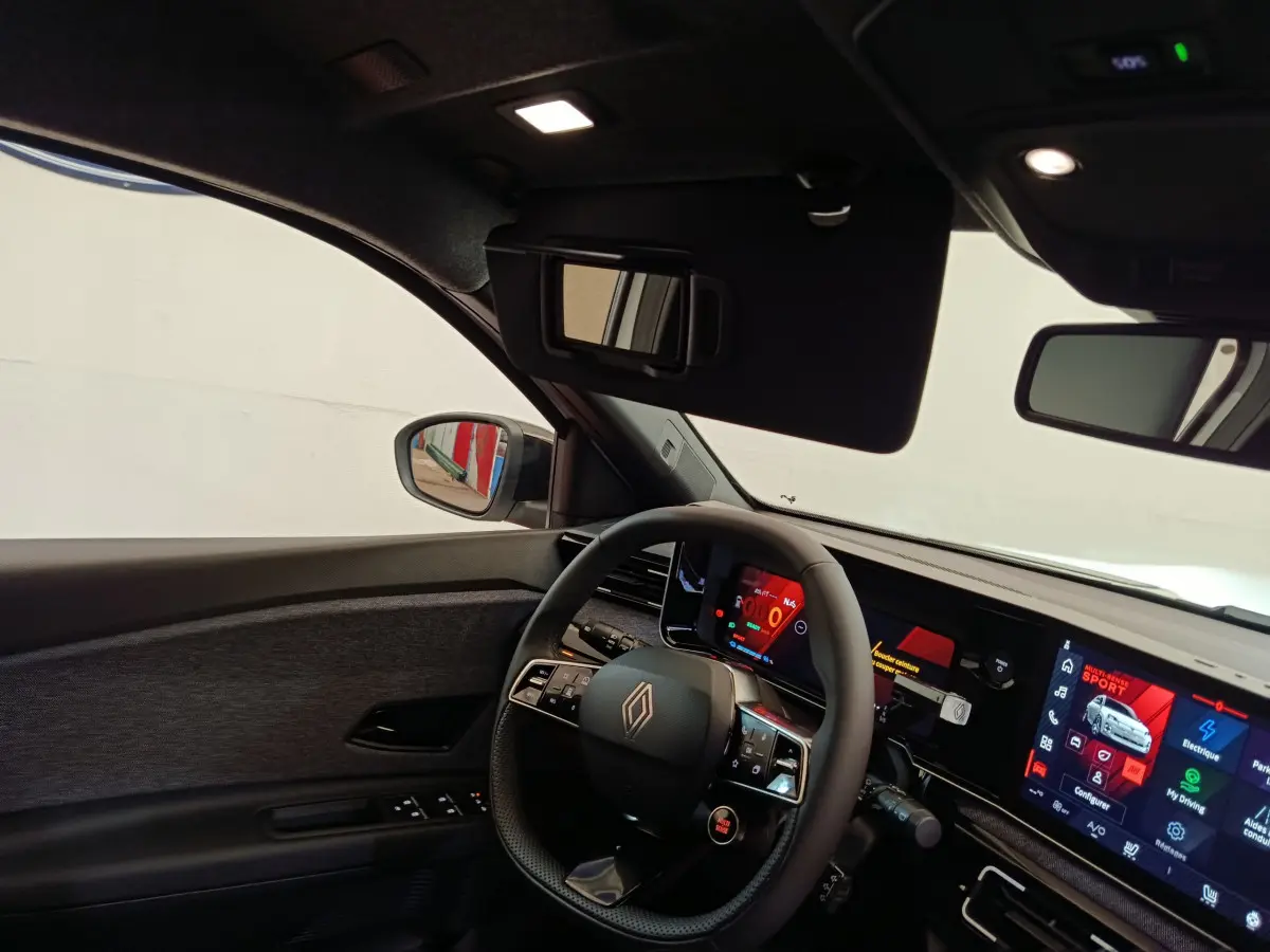 Vue intérieure côté conducteur de la Renault R5 Techno 150 ch blanc, avec volant multifonctions et écran tactile large.