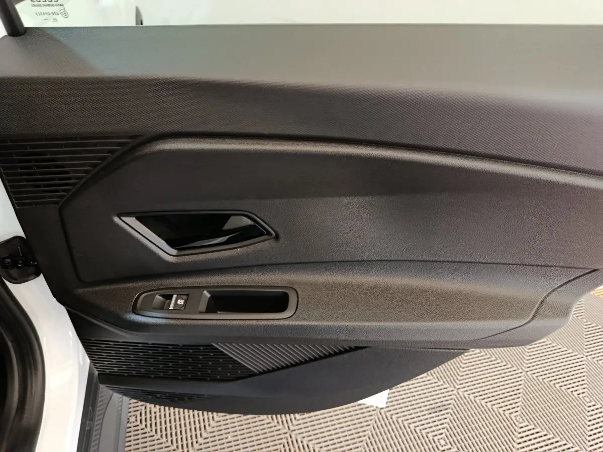 Vue rapprochée de la porte intérieure côté gauche blanche de la Renault R5 Techno 150 ch avec poignée noire et commande de vitre.