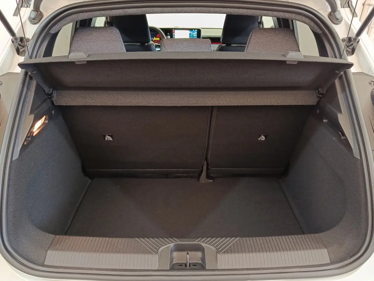 Vue du coffre arrière ouvert d'une Renault R5 Techno 150 ch blanc, avec banquette arrière rabattable 2/3-1/3 visible.