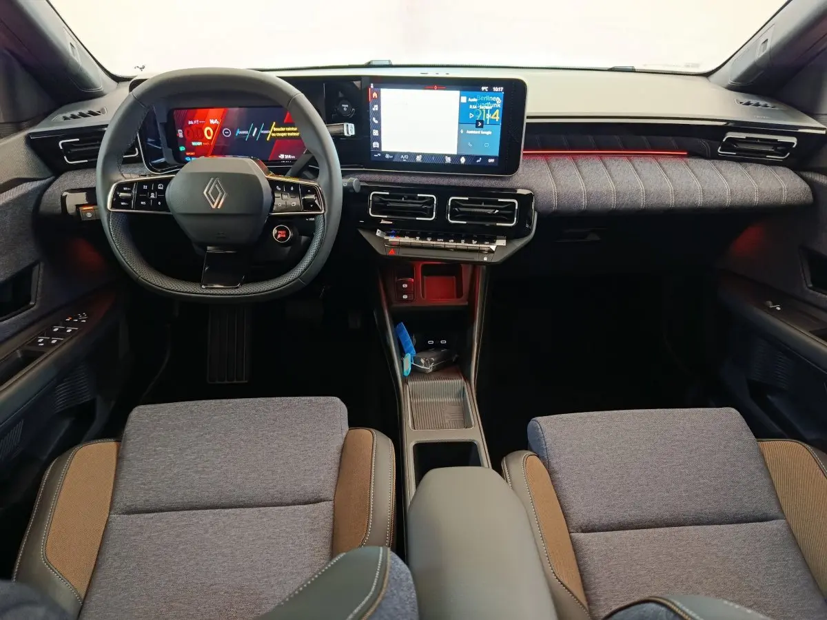 Vue intérieure avant de la Renault R5 Techno 150 ch 2025, tableau de bord moderne avec écran tactile et volant multifonctions.